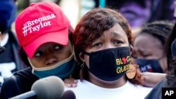Tamika Palmer, right, the mother of Breonna Taylor, listens to a news conference, Sept. 25, 2020, in Louisville, Ky. 