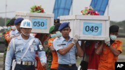 ក្រុម​ទីភ្នាក់ងារ​ស្វែងរក​ និង​ជួយ​សង្រ្គោះ​លី​ក្តារ​មឈូស​ដាក់​សាកសព​ជនរងគ្រោះ​ពី​ការ​ធ្លាក់​ជើង​យន្តហោះ​AirAsia Flight 8501។