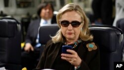 រូប​ឯកសារ៖ លោក​ស្រី Clinton ឆែក​មើល​ទូរស័ព្ទ​របស់​លោក​ស្រី​នៅ​ក្នុង​យន្តហោះ​យោធា​កាល​ពី​លោក​ស្រីនៅ​ជា​រដ្ឋ​មន្ត្រី​ក្រសួង​ការបរទេស​អាមេរិក។