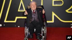 FILE - Britain Star Wars The Force Awakens Premiere: Kenny Baker poses for photographers upon arrival at the European premiere of the film 'Star Wars: The Force Awakens ' in London, Wednesday, Dec. 16, 2015.