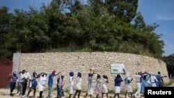 FILE - Supporters gather to pray outside the church of St. Rock for the release of clergy members, including two French citizens, who were kidnapped, in Port-au-Prince, Haiti, April 12, 2021.