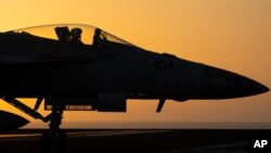 FILE - A fighter jet maneuvers on the deck of the USS Dwight D. Eisenhower in the Red Sea, June 11, 2024. 