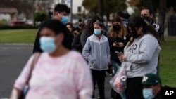 FILE - People wait in line for a COVID-19 test at a mobile testing site in Paramount, California, Jan. 12, 2022. (AP Photo/Jae C. Hong)