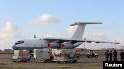 Workers load humanitarian aid from United Nations onto a plane for Syrian families, in Erbil airport, about 350 km (220 miles) north of Baghdad, Dec. 15, 2013. 