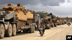 Turkish military convoy drives through the village of Binnish, in Idlib province, Syria, eb. 8, 2020. 