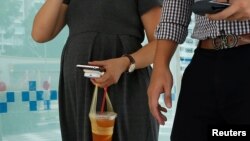 A pregnant couple walk together in Singapore, September 1, 2016. Singapore has reported hundreds of cases of Zika which has been linked to birth defects.