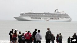 FILE - People prepare to take a polar plunge in the Bering Sea in front of the luxury cruise ship Crystal Serenity, which anchored just outside Nome, Alaska, Aug. 21, 2016. The ship made a port call as it became the largest cruise ship to ever go through the Northwest Passage, en route to New York City.