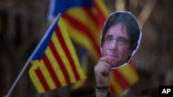 A demonstrator holds a cut-out of Catalonia's ex-president Carles Puigdemont during a protest outside Catalonia's parliament in Barcelona, Spain, Jan. 30, 2018. 