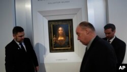 Security guards set up a rope in front of "Salvator Mundi" by Leonardo da Vinci during a news conference at Christie's in New York, Oct. 10, 2017.