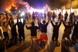 Demonstrators kneel before police Saturday, May 30, 2020, in Minneapolis. Protests continued following the death of George Floyd, who died after being restrained by Minneapolis police officers on Memorial Day.