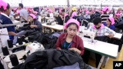 រូបឯកសារ៖ កម្មកររោងចក្រ​កម្ពុជា​ដេរ​​សម្លៀកបំពាក់​ក្នុង​រោងចក្រ​មួយ ក្នុង​តំបន់​សេដ្ឋកិច្ច​ពិសេស​ នៅ​ជាយ​រាជធានី​ភ្នំពេញ កាល​ពី​ថ្ងៃ​ពុធ​ ទី​២៣ ខែសីហា ឆ្នាំ​២០១៧។ (AP Photo/Heng Sinith) 