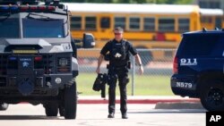 A law enforcement officer walks in the parking lot of Timberview Hight School after a shooting inside the school in south Arlington, Texas, Oct. 6, 2021.