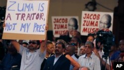 Protesters raise placards against South African President Jacob Zuma in Johannesburg, April 1, 2017, during a memorial service for anti-apartheid stalwart Ahmed Kathrada. The memorial service for Kathrada turned into a protest against Zuma.