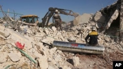 Syrian rescuers search for victim between rubble of a destroyed house after deadly airstrikes at the northern town of Sarmin, in Idlib province, Syria, Sunday, Feb. 2, 2020. (AP Photo/Ghaith Alsayed)