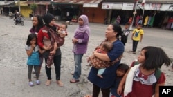 Arsip - Penduduk berkumpul di luar rumah setelah terjadi gempa bumi di Aceh.