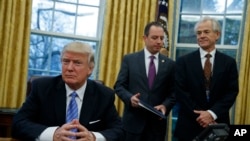 白宫全国贸易委员会主任彼得·纳瓦罗（Peter Navarro，右）等待川普总统签署政令（2017年1月23日）