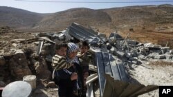 Seorang perempuan Palestina membawa anak-anaknya setelah rumahnya di Desa Aqraba, hancur. Aqraba terletak dekat permukiman Itamar, Nablus, West Bank.