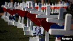 A photograph hangs from one of the 58 white crosses set up for the victims of the Route 91 music festival mass shooting in Las Vegas, Nevada, Oct. 5, 2017.