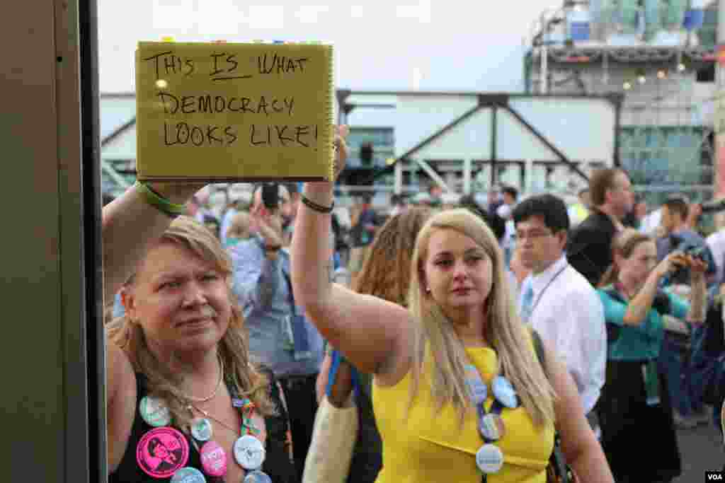 Bernie Sanders supporters hold protest signs after Hillary Clinton formally won the Democratic nomination. (A. Shaker/VOA)