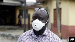 A man wearing a face mask walks outside Yaba Mainland hospital where an Italian citizen - the country's first case of the COVID-19 virus - is being treated, in Lagos, Nigeria, Feb. 28, 2020. 