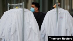 A worker delivers protective lab coats to the headquarters of Moderna Therapeutics, which is developing a vaccine against the coronavirus disease, in Cambridge, Massachusetts, U.S., May 18, 2020. 