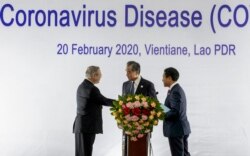 China's Foreign Minister Wang Yi, center, talks with Philippines Foreign Affaires Secretary Teodoro Locsin Jr., left and Laos Foreign Minister Saleumxay Kommasith following a press conference of the Co-Chairs Special ASEAN-China Foreign Minister.