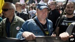 Ilya Osipov, center, attends an opposition rally in Moscow downtown, Russia, May 6, 2017. People gather for the rally against the Kremlin and demanding the release of political prisoners, five years since the opposition protest at May 6, 2012, that ended in violent clashes between demonstrators and police. 