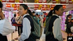 FILE - Students wait to attend tutoring classes after school in Hong Kong Wednesday, Dec. 4, 2013. In Hong Kong, attending an after school tutorial academy is standard practice for many students. (AP Photo/Kin Cheung)