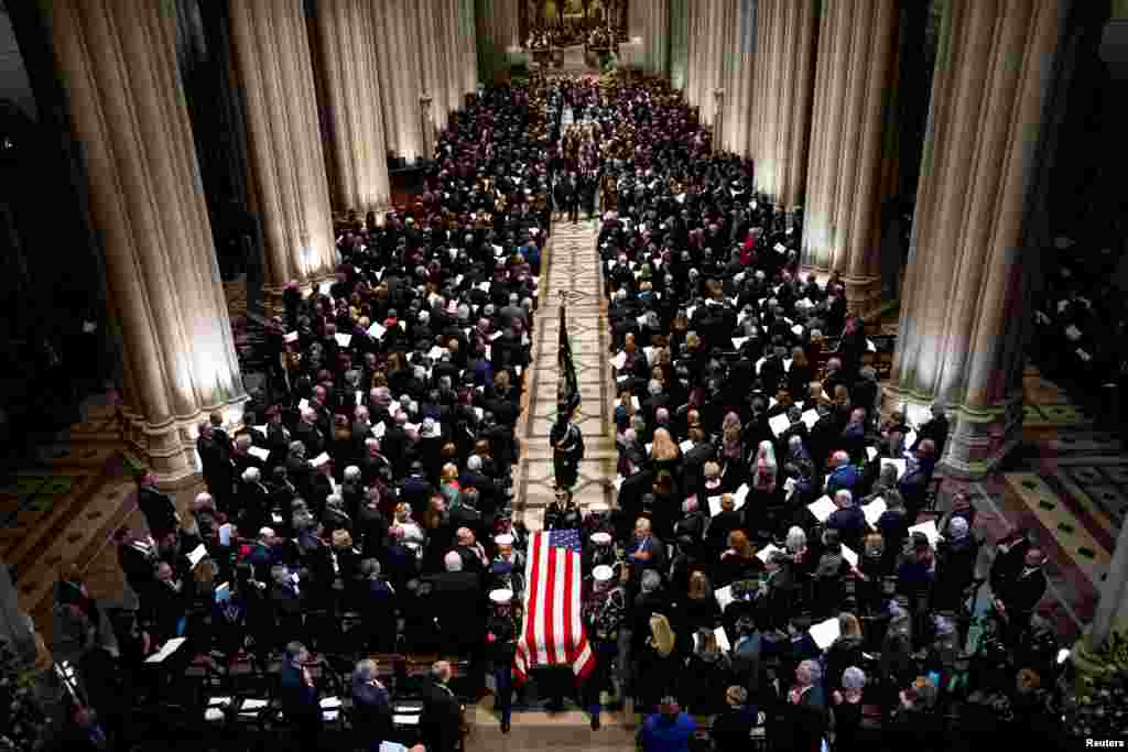 The Honor Guard carries the casket of former president George Herbert Walker Bush down the center isle following a memorial ceremony at the National Cathedral in Washington, Dec. 5, 2018. 