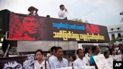FILE - Activists hold placards during a protest against the killing of Aung Kyaw Naing, a freelance journalist, outside the city hall in Yangon, Myanmar, Oct. 26, 2014. 