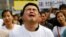 A family member of a passenger on board Malaysia Airlines MH370 cries as he shouts slogans during a protest in front of the Malaysian embassy in Beijing, March 25, 2014. 