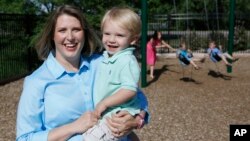 Christy Wolford, a breast cancer survivor, had her ovaries suppressed during cancer treatment and she has had three boys since treatment ended in 2006. She holds son Lucas, 2, as her other children play in the background in Fort Collins, Colo., May 29, 2014.