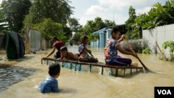 រូបឯកសារ៖ ក្មេងៗ​​លេង​នៅ​តាម​ផ្លូវ​ដែល​ជន់លិច ដោយសារ​ទឹកជំនន់​ពី​ស្ទឹង​ព្រែកត្នោត នៅក្នុង​ភូមិពាម សង្កាត់​ព្រៃស ខណ្ឌដង្កោ រាជធានី​ភ្នំពេញ នៅ​ថ្ងៃទី២៦ ខែតុលា ឆ្នាំ២០២១។ (លាស់ លីបលីប/វីអូអេ)