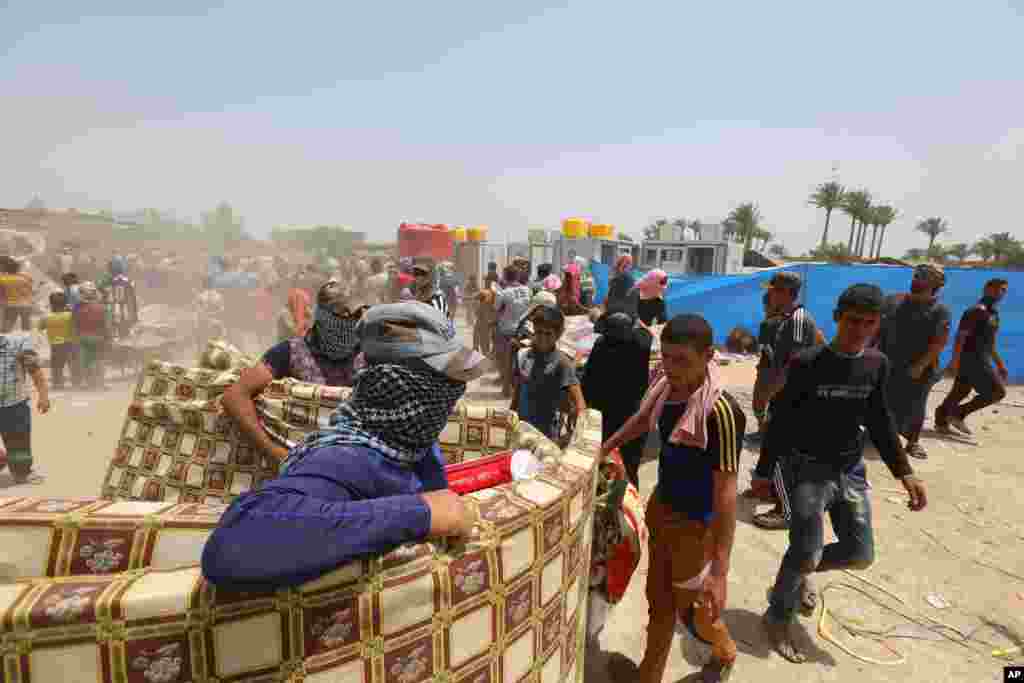 Displaced civilians from Ramadi receive humanitarian aid from the United Nations in a camp in the town of Amiriyat al-Fallujah, west of Baghdad, May 22, 2015.