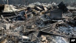 Jon Marshall looks through the debris of his home among the at Coleman Creek Estates mobile home park in Phoenix, Ore., Sept. 10, 2020. 