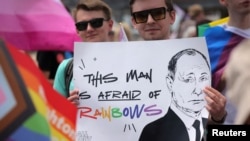 FILE - Participants in the Brooklyn Pride Parade hold a sign that reads, "Putin is afraid of rainbows," May 19, 2024.