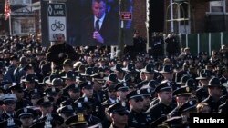 At crowded funeral for slain NYPD Officer Rafael Ramos, many officers turn their backs to shun New York City Mayor Bill de Blasio as he delivers eulogy, Dec. 27, 2014.