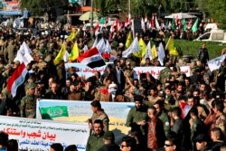 FILE - Iran-backed Popular Mobilization Forces gather outside the heavily fortified Green Zone, the seat of Iraq's government and the U.S. embassy, in Baghdad, Iraq, Dec. 31, 2019.