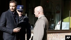 Italian journalists Gianluigi Nuzzi (R), and Emiliano Fittipaldi (L) talk with a Vatican Gendarmie guard at the Vatican City's Perugino entrance Nov. 24, 2015. 