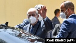 Le président algérien Abdelmadjid Tebboune salue en partant après avoir voté dans un bureau de vote à Bouchaoui, dans la banlieue ouest d'Alger, la capitale de l'Algérie, le 12 juin 2021, lors des élections législatives de 2021. 