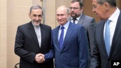 Presiden Rusia Vladimir Putin (tengah), berjabat tangan dengan Ali Akbar Velayati, penasihat senior untuk Pemimpin Tinggi Iran Ayatollah Ali Khamenei, yang didampingi oleh Menteri Luar Negeri Iran Sergey Lavrov (kanan) di Novo-Ograyovo di luar Moskow, Rusia, 12 Juli 2018.
