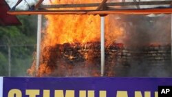 FILE - Flames and smoke rise from burning illegal drugs during a destruction ceremony to mark International Day against Drug Abuse and Illicit Trafficking outside Yangon, Myanmar, June 26, 2020. 