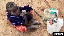 A Somali refugee girl waits for her turn to collect water from a tank at the Ifo extension refugee camp in Dadaab, near the Kenya-Somalia border, July 31, 2011. 