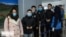 FILE - Chinese travelers wearing face masks to protest against the coronavirus undergo a health screening upon arrival at an Iranian airport in this undated photo published by IRNA on Jan. 30, 2020 (Credit: IRNA)