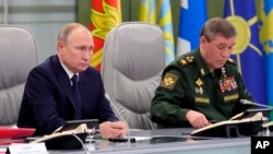 블라디미르 푸틴 러시아 대통과 발레리 게라시모프 총참모장이 26일 모스크바의 국방부 통제실에서 '아반가르드' 극초음속 미사일 발사 시험을 참관했다.