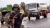 A Liberian soldier stops people at a security checkpoint set up to clamp down on people trying to travel to the capital from rural areas hard-hit by the Ebola virus, on the outskirts of Monrovia, Aug. 7, 2014.