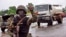 A Liberian soldier stops people at a security checkpoint set up to clamp down on people trying to travel to the capital from rural areas hard-hit by the Ebola virus, on the outskirts of Monrovia, Aug. 7, 2014.