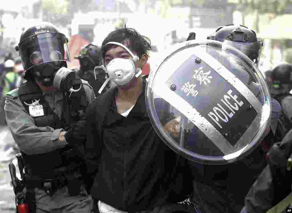 Police officers detain a protester near the Hong Kong Polytechnic University in Hong Kong, Monday, Nov. 18, 2019. Hong Kong police have swooped in with tear gas and batons as protesters who have taken over a university campus make an apparent last…