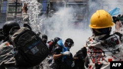 ក្រុមអ្នកតវ៉ានាំគ្នាបាញ់ទឹកដើម្បីទប់ទល់នឹងឧស្ម័នបង្ហូរទឹកភ្នែកដែលប៉ូលិសបានបាញ់ដើម្បីបង្ក្រាបការប្រមូលផ្តុំរបស់ក្រុមអ្នកតវ៉ាប្រឆាំងនឹងរដ្ឋប្រហារយោធានៅទីក្រុងរ៉ង់ហ្គូន ប្រទេសមីយ៉ាន់ម៉ា ថ្ងៃទី២ ខែមីនា ឆ្នាំ២០២១។