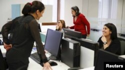 FILE - Employees of multinational headhunter Korn/Ferry work at the company's offices in Caracas, Venezuela, Aug. 3, 2015. 